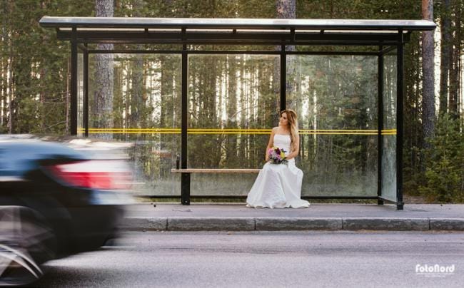 a lonely bride waiting on a bus stop