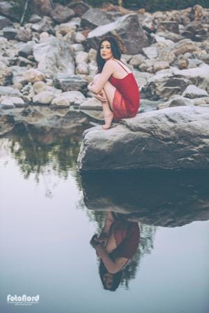 girl in red dress at the water's edge